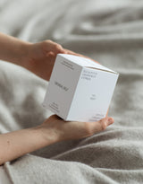 A person holding an Original Self candle product box.